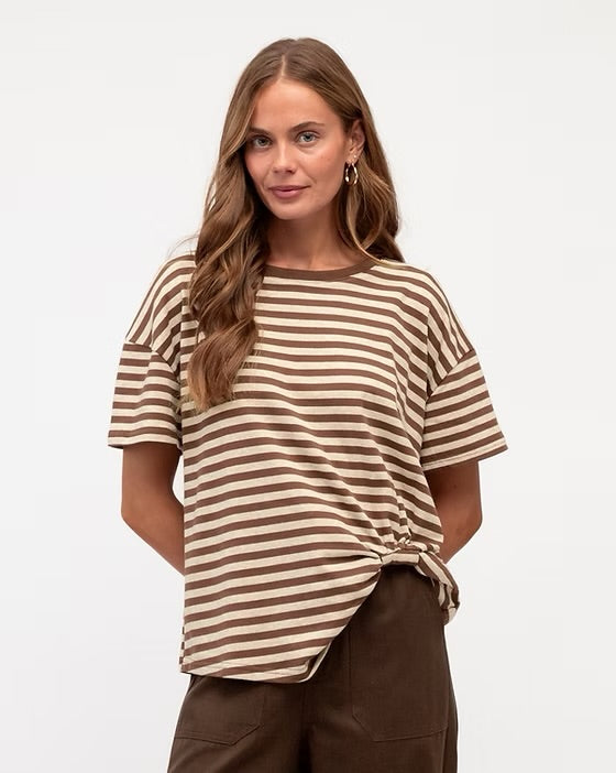 Woman wearing a brown and beige striped shirt against a white background