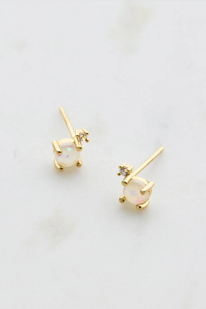Delicate gold stud earrings featuring white opal and clear crystal