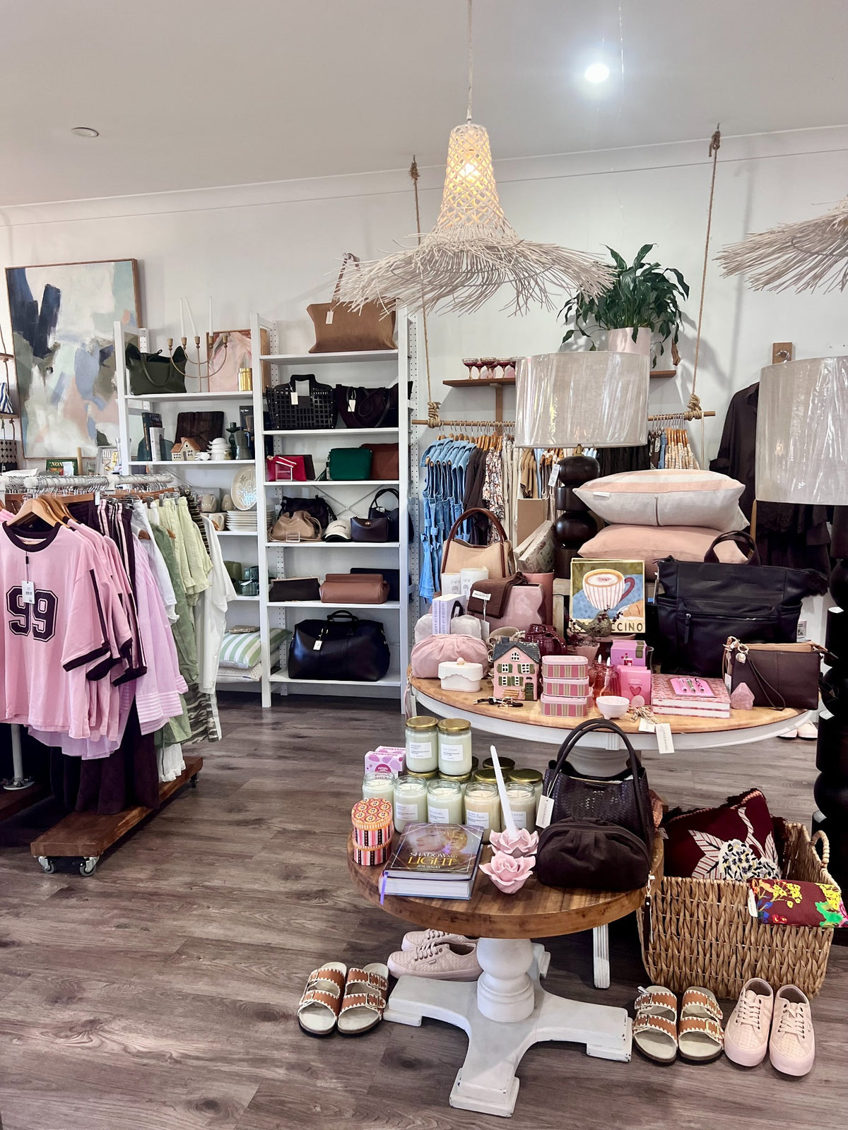 Inside Folk and Co boutique showing fashion, handbags and gifts displayed on timber tables