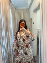 Woman wearing the Autumn Bloom Floral Tie Waist Midi Dress with an autumn floral print and adjustable waist tie.